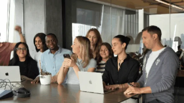 A team waving hello from inside the office that could build it themselves